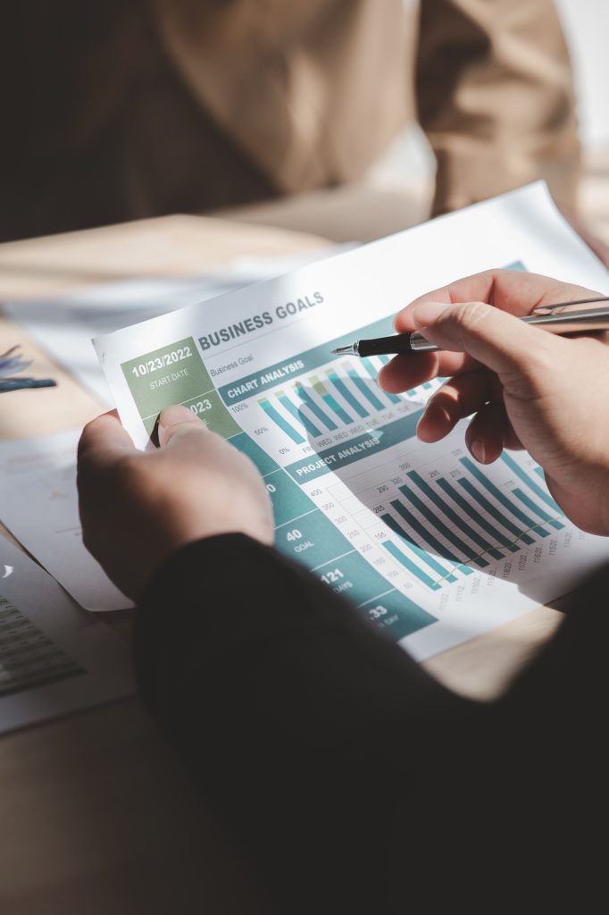 Businessman is reviewing monthly sales documents for analysis.